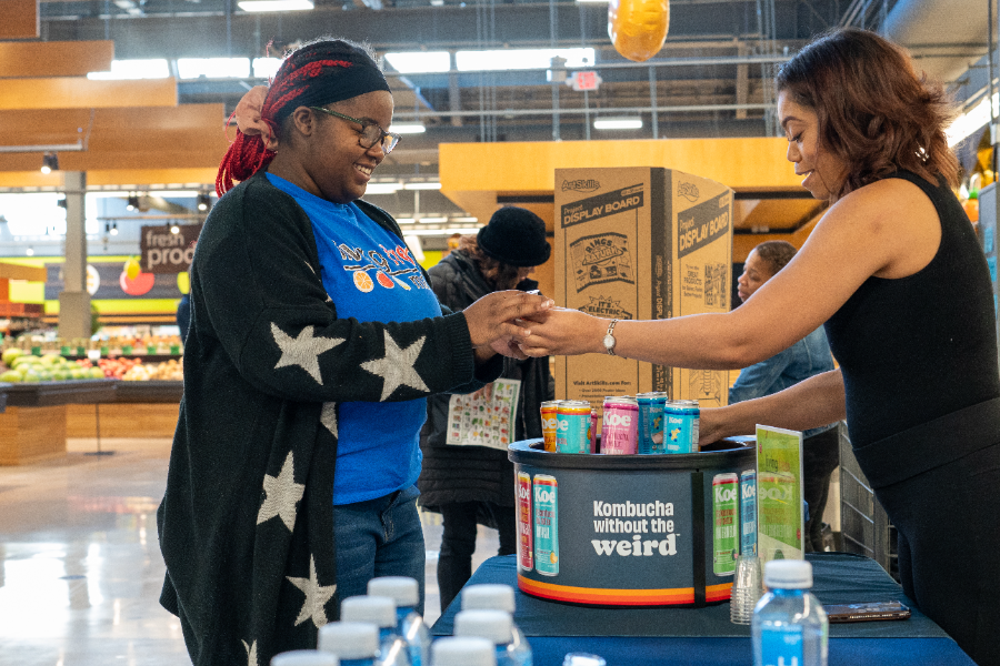 A vendor handing a shopper a sample